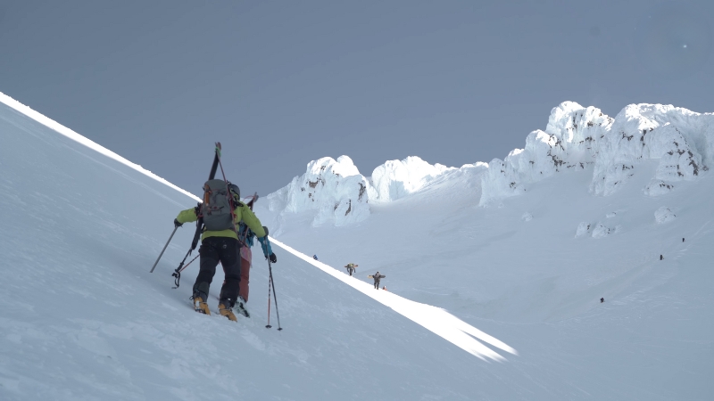 Climbers ascend a steep snowy slope on Mount Hood during a technical mountaineering route