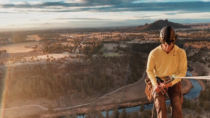 A climber prepares on a cliff above a river in Oregon, capturing the spirit of outdoor adventures for thrill-seekers