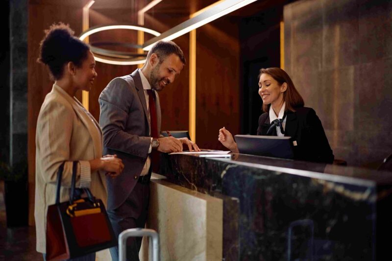 Hotel guests speaking with a receptionist at a front desk during check in