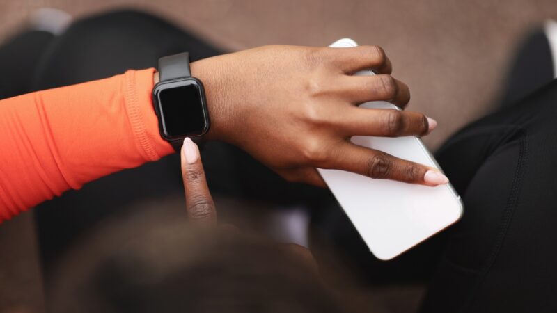 A gym member checks a smartwatch after class