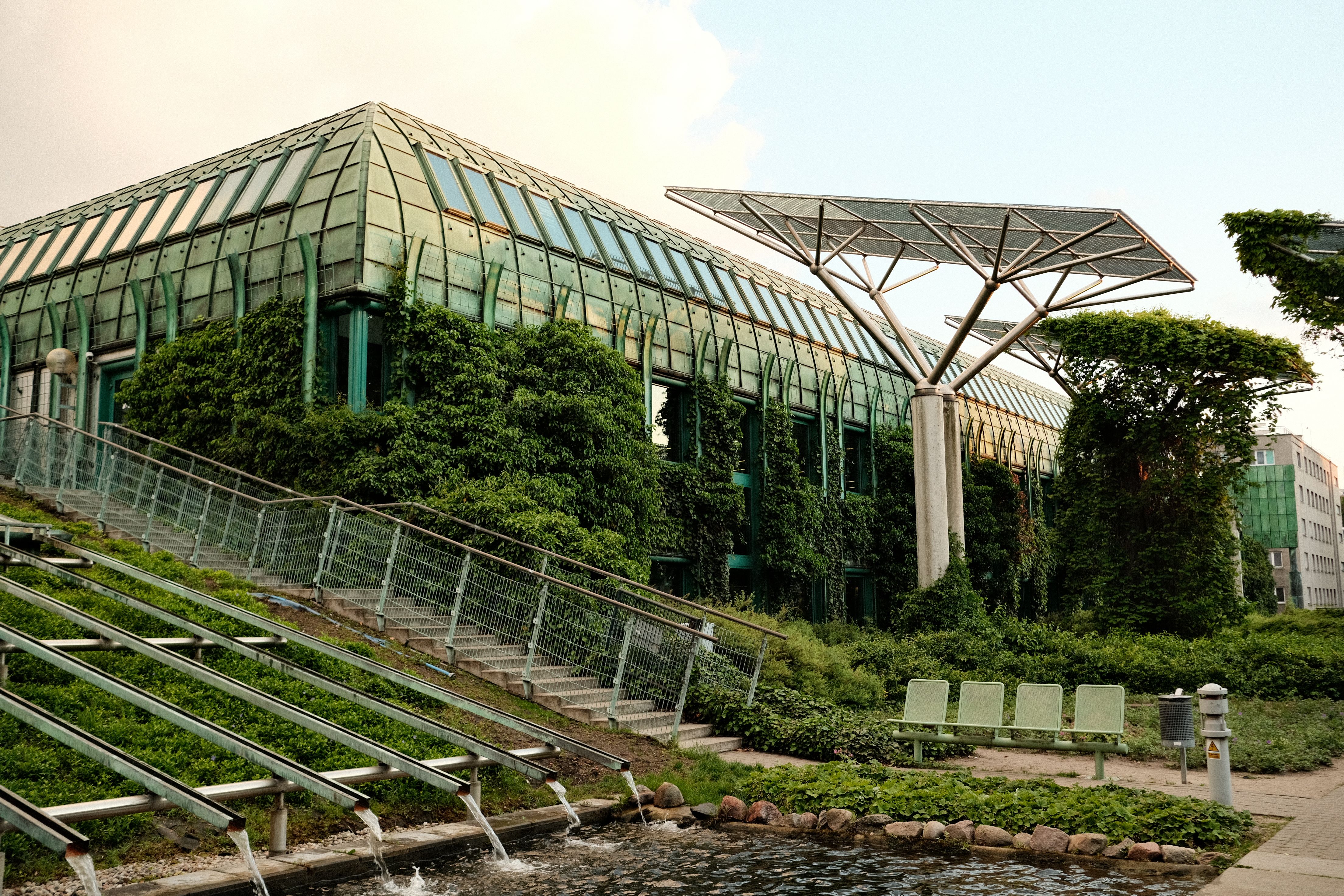 Eco-friendly building with rooftop gardens and solar panels, representing integrated sustainable design for institutional buildings.