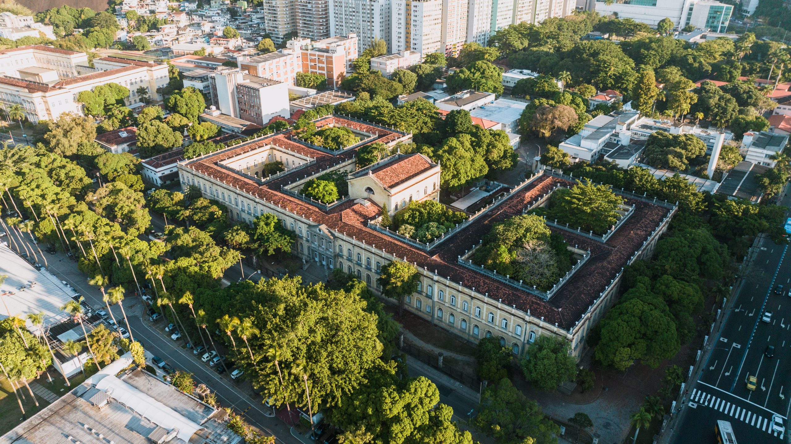 Aerial view of a historic university campus surrounded by lush greenery, illustrating landscape-led campus planning.