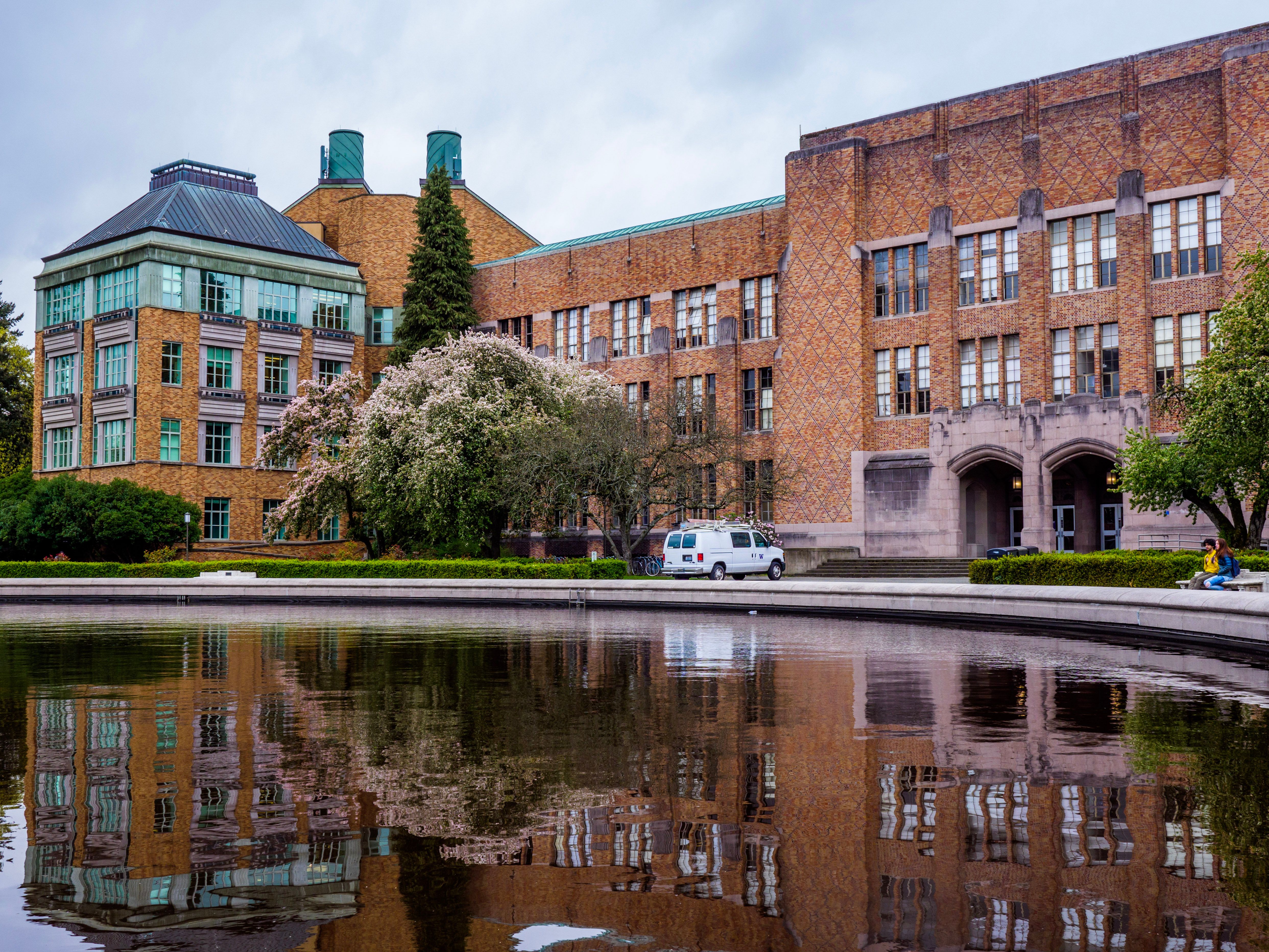 University campus buildings reflected in a tranquil pond, highlighting water-sensitive landscape design and biodiversity.