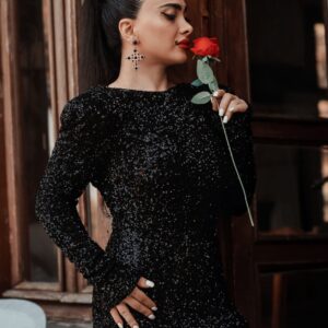 Elegant woman in a black sequined dress holding a red rose, exuding class and romance